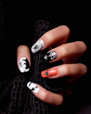 Detalhe das mãos de uma manicure pintando as unhas com um desenho de  esmalte preto